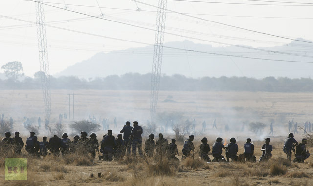 Policemen fire at striking miners outside a South African mine in Rustenburg