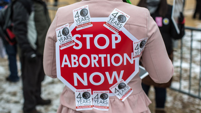 An anti-abortion protester has a sign stuck to her back with stickers at the March for Life on January 25, 2013 in Washington, DC (Brendan Hoffman/Getty Images/AFP)