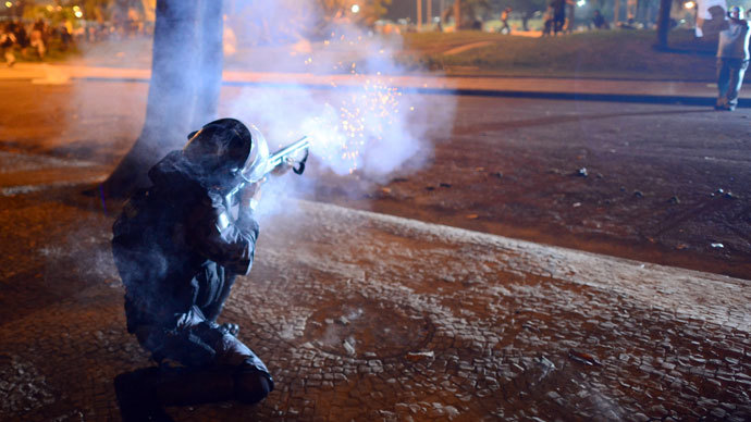 A riot police officer fires rubber bullets after clashes erupted during a protest against corruption and price hikes, on June 20, 2013, in Rio de Janeiro.(AFP Photo / Christophe Simon)