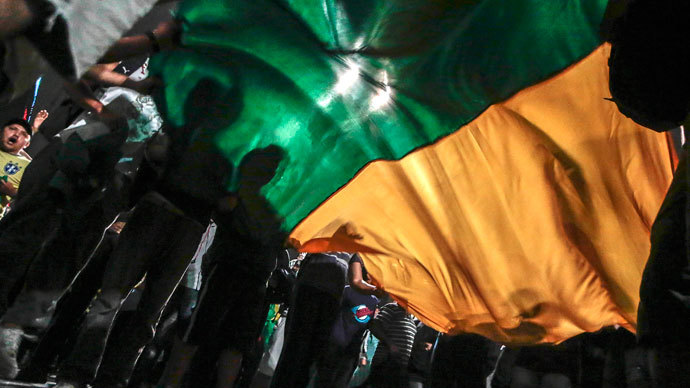 Demonstrators hold flag during a protest of what is now called the 'Tropical Spring' against corruption and price hikes in Sao Paulo, Brazil, on June 20, 2013.(AFP Photo / Miguel Schincariol)