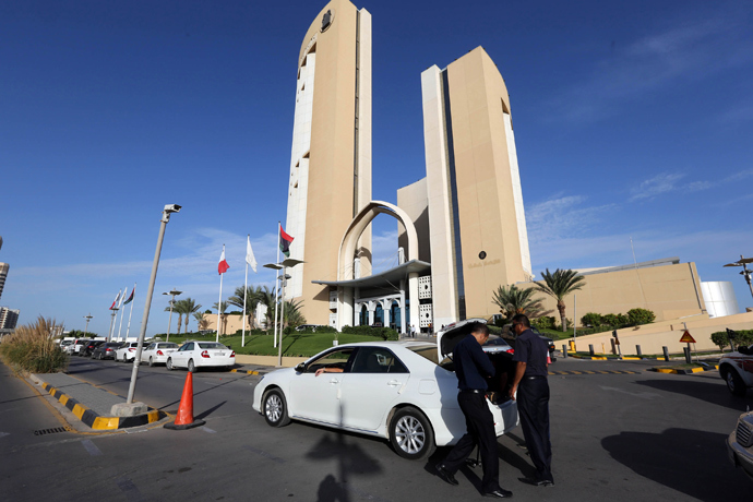 A general view taken on October 10, 2013 shows security checking a vehicle outside the Corinthia hotel (background) in the Libyan capital Tripoli after Libyan Prime Minister Ali Zeidan was kidnapped from the hotel (AFP Photo / Mahmud Turkia)