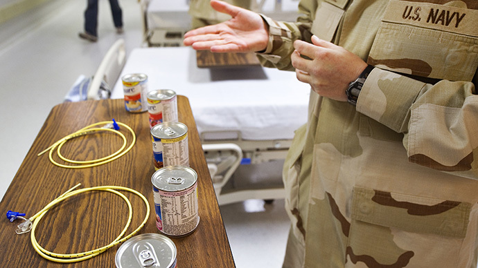 A US Navy doctor shows the feeding tubes and cans of Ensure nutritional liquid given to detainees on hunger strikes or not eating inside Camp Delta in the Detention Center at Guantanamo Bay, Cuba. (AFP Photo / Paul J. Richards)
