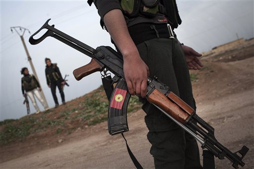 FLE - In this Sunday, March. 3, 2013 file photo, Kurdish female members, foreground and background, of the Popular Protection Units stand guard at a check point near the northeastern city of Qamishli, Syria.