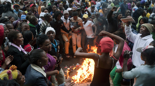 RODGER BOSCH/AFP/Getty Images People taking part in a protest agaianst poor public services sing and dance around a rubbish fire on October 30, 2013, in the centre of Cape Town. The people congregated outside the Western Cape provincial Legislature, calling for Western Cape Premier(not visible) to come and address them.
