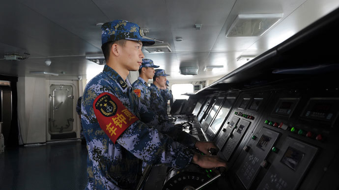 Chinese naval soldiers are pictured manning their stations on China's first aircraft carrier Liaoning, as it travels towards a military base in Sanya, Hainan province, in this undated picture made available on November 30, 2013. (Reuters / Stringer)